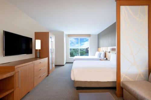 a hotel room with two beds and a flat screen tv at Hyatt Place Westminster Denver in Westminster