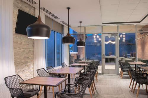 a restaurant with tables and chairs and large windows at Hyatt Place Westminster Denver in Westminster