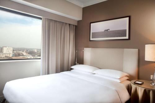 a bedroom with a large white bed and a window at Hyatt Regency Bishkek in Bishkek