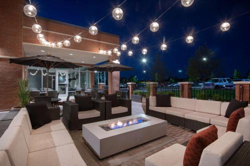 a patio with couches and a fire pit at night at Hyatt Place Westminster Denver in Westminster
