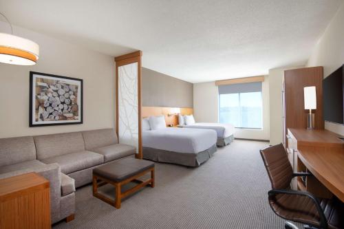 pokój hotelowy z łóżkiem i kanapą w obiekcie Hyatt Place Westminster Denver w mieście Westminster