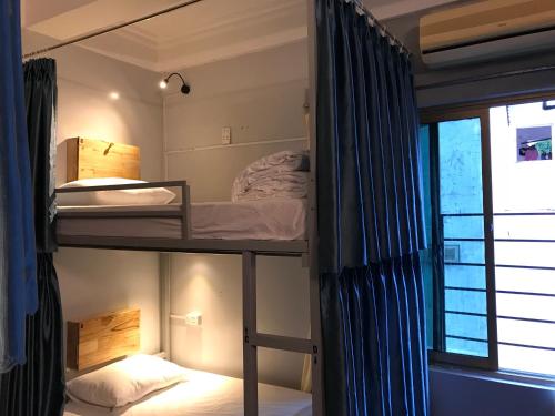 Ce dortoir comprend 2 lits superposés et une fenêtre. dans l'établissement Luna's House Hostel, à Cat Ba