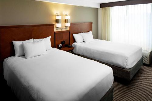 a hotel room with two beds and a window at Hyatt Place Dallas Park Central in Dallas