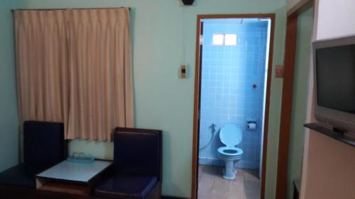 a bathroom with a blue toilet and a television at Singapore Hotel in Hat Yai