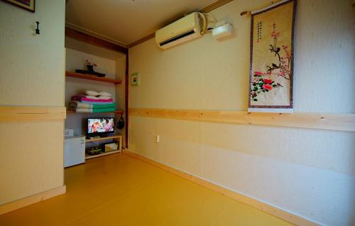 a living room with a yellow floor and a tv at Jungdam in Jeonju