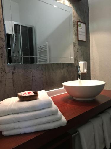 a bathroom with a sink and towels on a counter at Pension Am Pollingpark in Dessau