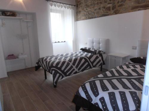 una camera con due letti con lenzuola bianche e nere di TIA casa vacanza a Bevagna