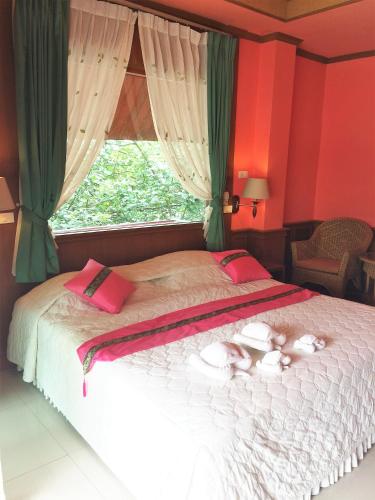 a bedroom with a bed with dolls on it at Cookies Hotel in Ko Chang
