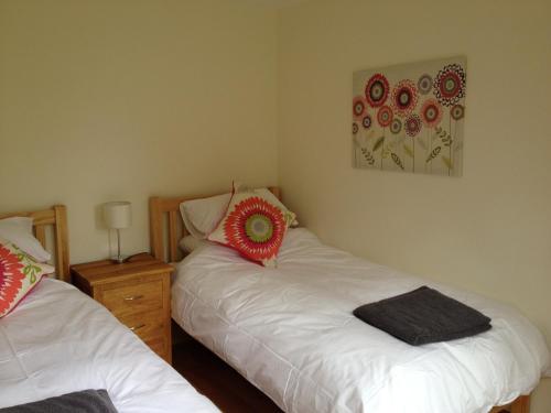 a bedroom with two beds and a painting on the wall at Ashbrook Lets Apartments in Blewbury