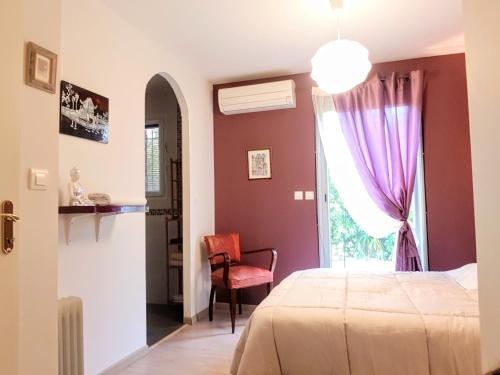 ein Schlafzimmer mit einem Bett, einem Fenster und einem Stuhl in der Unterkunft Maison neuve avec jardin au calme in La Crau
