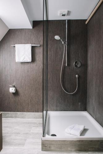 a bathroom with a shower and a bath tub at Boutique Hotel Pfauen in Schorndorf