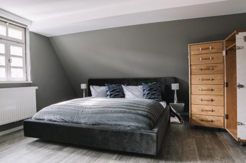 a bedroom with a black bed and a dresser at Boutique Hotel Pfauen in Schorndorf