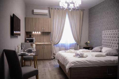 Apart hotel Lake Apartments في كييف: غرفة نوم بسرير كبير ومكتب ونافذة
