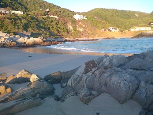 a view of a beach with rocks and the ocean at Shick-Shack in Eersterivierstrand