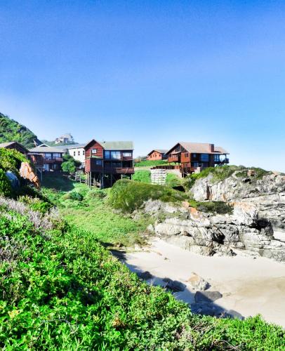 a row of houses on a hill next to a beach at Shick-Shack in Eersterivierstrand