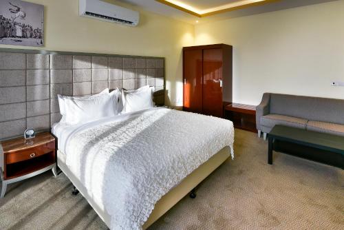 a hotel room with a bed and a chair at Golden dune Hotel Services-Turaif in Ţurayf