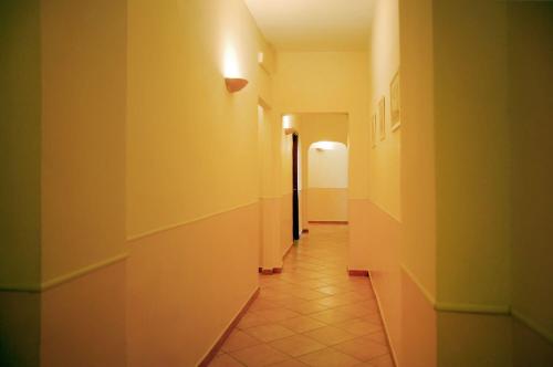 a hallway with yellow walls and a tile floor at Hotel Ristorante Benigni in Campagnano di Roma