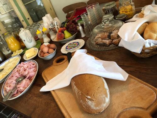 a table with a loaf of bread and other breakfast foods at Penzion V polích in Malé Číčovice