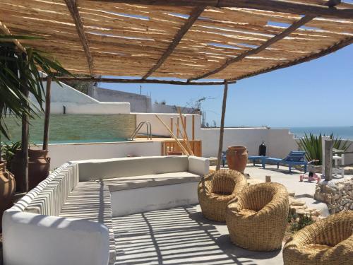 a patio with a couch and chairs under a pergola at Villa Jardin De l'Ocean in Aourir