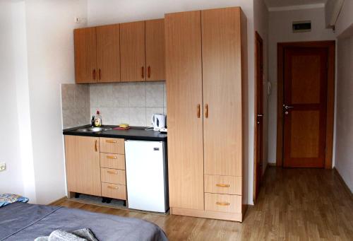 a small kitchen with wooden cabinets and a white refrigerator at Apartments Astoria HN in Herceg-Novi