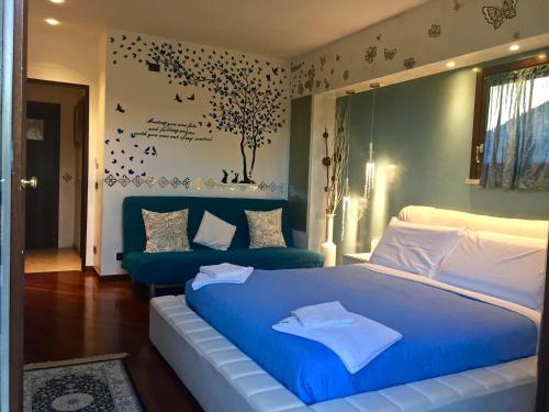 a bedroom with a blue bed and a tree on the wall at B&B Garda 4U in Desenzano del Garda