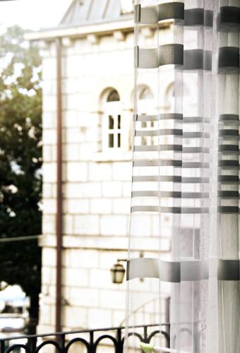 a white building with a window with a flag at Apartments Astoria HN in Herceg-Novi