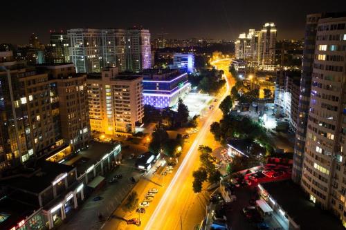 a city lit up at night with buildings and cars at IRIS apartments in Odesa