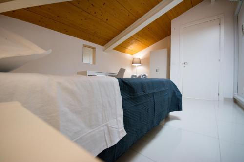 a bedroom with a bed with a blue blanket at Palazzo di Fazio Suites in San Severo