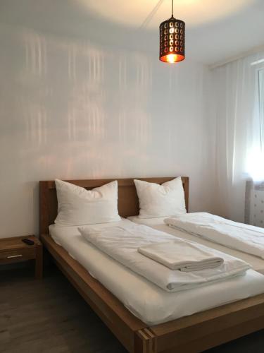 a bedroom with two beds with white sheets and a chandelier at Rheinstraße 33 in Mainz