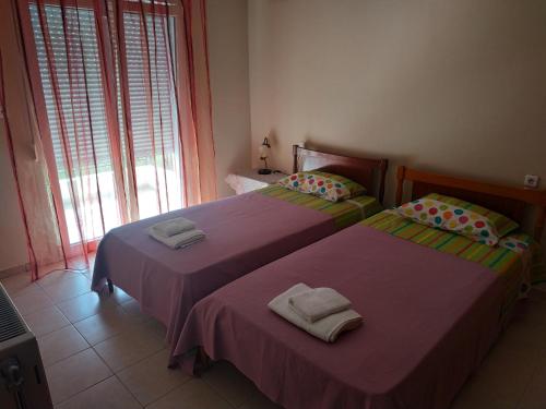two beds sitting next to each other in a bedroom at Apartment Next to Coast in Nea Anchialos