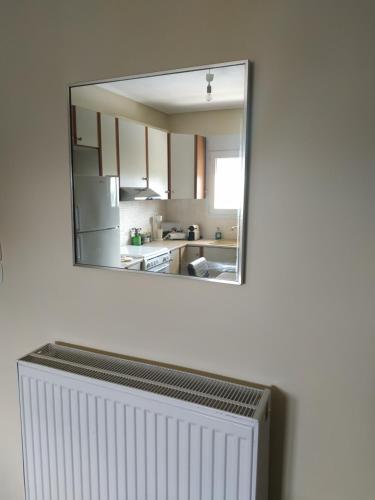 a mirror on a wall above a radiator in a kitchen at Apartment Next to Coast in Nea Anchialos