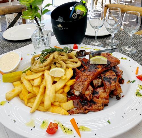 a plate of food with french fries and meat at Cape St Francis Resort in Cape St Francis