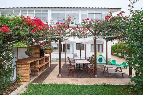a patio with a table and chairs and flowers at Beija-Flor House in Ribamar