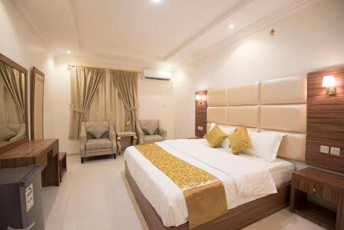 a bedroom with a large bed and a television at Janan Al Nakheel Serviced Apartments in Al Muzāḩimīyah