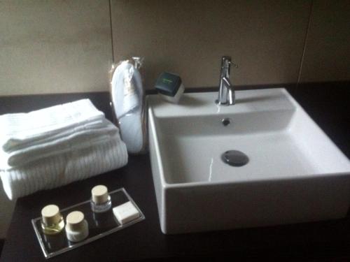a bathroom with a white sink and towels at Hotel Principe Di Torino in Turin