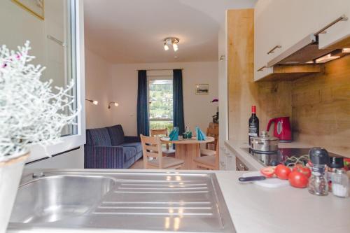a kitchen with a sink and a living room at Ferienhäuser Tröster in Bad Kleinkirchheim