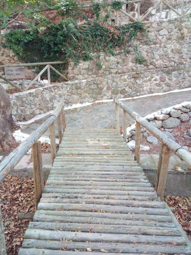 a wooden pathway leading up to a stone wall at Dimitra Apartments Zakros Village in Káto Zákros