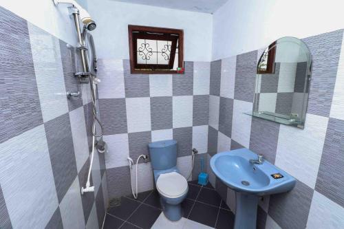 a bathroom with a blue toilet and a sink at Chrish Residence in Negombo