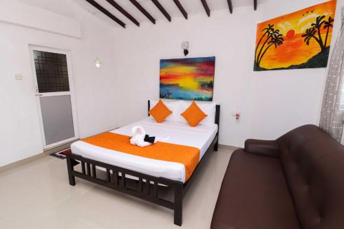 a bedroom with a bed with a cat sitting on it at Chrish Residence in Negombo