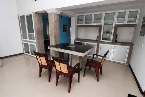 a kitchen with a table and chairs in a room at Chrish Residence in Negombo