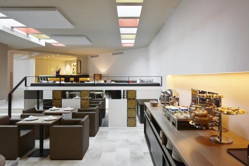 a restaurant with tables and chairs in a room at Hotel Palladium in Palma de Mallorca