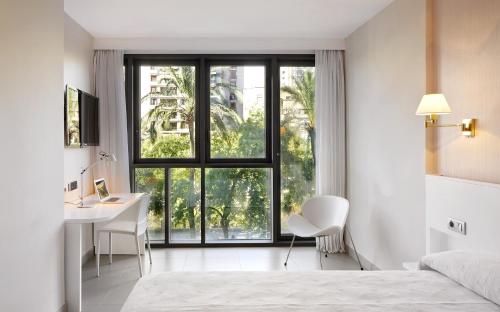 a bathroom with a large window and a large bed at Hotel Palladium in Palma de Mallorca