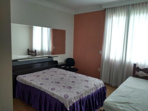a hotel room with a bed and a piano at Casa verde in Belo Horizonte