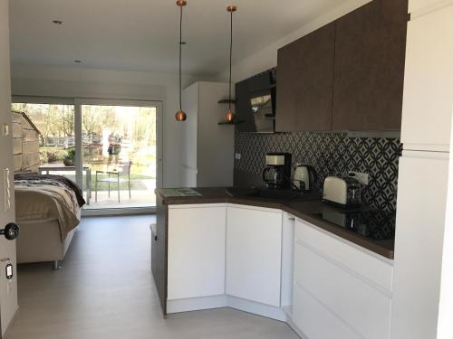a kitchen with white cabinets and a bed in a room at Ferienwohnungen direkt am Wasser in Burg