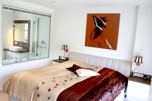 a bedroom with a bed and a painting on the wall at Ferienwohnungen direkt am Wasser in Burg