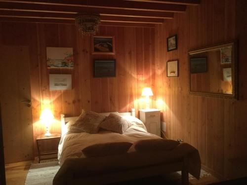 una camera con un letto con due luci accese di la maison face au port a Lège-Cap-Ferret