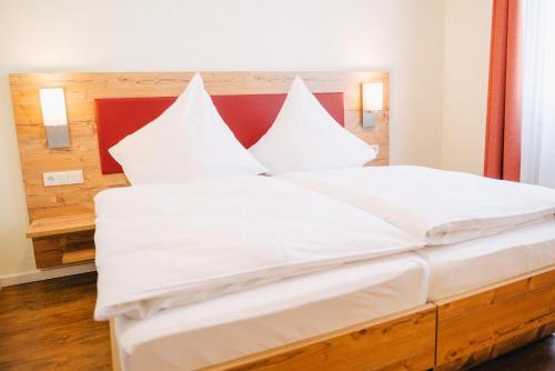 a large white bed with white sheets and pillows at Gasthaus Stroh in Buchholz