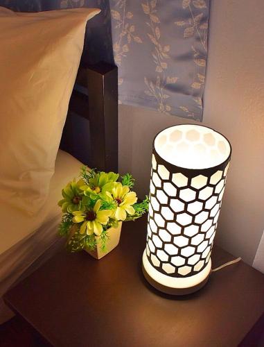 a table with a vase with yellow flowers on it at Mango House in Sukhothai