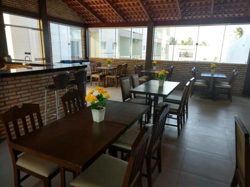 a restaurant with tables and chairs with flowers on them at Hotel Costa do Delta in Tutóia