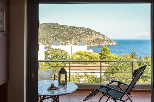 einen Balkon mit Meerblick, einem Tisch und Stühlen in der Unterkunft Serenity apartment-1st floor-Sea view- beach 200m away in Porto Rafti